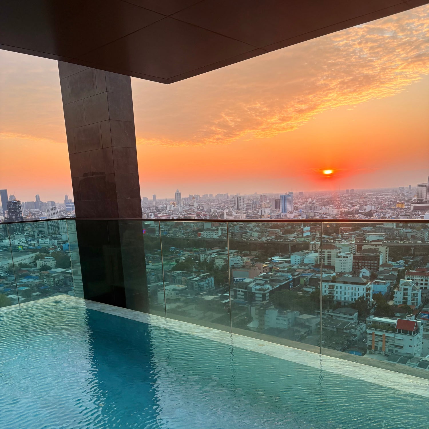 Cityscape view from an indoor pool with sunset